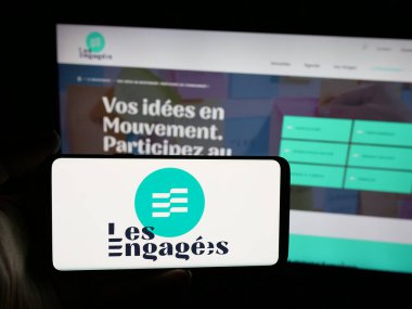 Stuttgart, Almanya - 07-11-2025: İnternet sitesinin önünde Belçika siyasi partisi Les Engages 'in (LE) logosunu taşıyan kişi. Telefon ekranına odaklan.