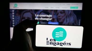 Stuttgart, Almanya - 07-11-2025: İnternet sayfasının önünde Belçika siyasi partisi Les Engages 'in (LE) logosunu elinde tutan kişi. Telefon ekranına odaklan.