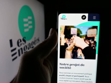 Stuttgart, Almanya - 07-11-2025: Belçika siyasi partisi Les Engages 'in (LE) web sayfası logonun önünde bulunan kişi. Telefon ekranının merkezine odaklan.