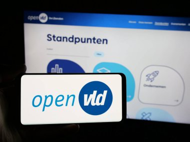 Stuttgart, Almanya - 07-11-2025: İnternet sitesi önünde üzerinde Open Vlaamse Liberalen en Democraten Open VLD logosu bulunan akıllı telefon sahibi kişi. Telefon ekranına odaklan.