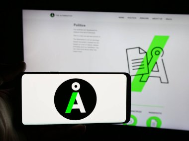 Stuttgart, Almanya - 07-11-2025: İnternet sitesi önünde ekranda Danimarkalı siyasi parti Alternativet 'in (A) logosuna sahip akıllı telefon tutan kişi. Telefon ekranına odaklan.