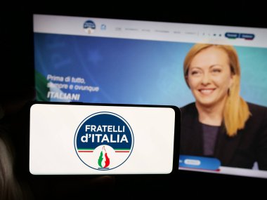 Stuttgart, Almanya - 07-11-2025: İnternet sitesi önünde üzerinde İtalyan partisi Fratelli d 'Italia' nın (FDL) logosu bulunan akıllı telefon sahibi kişi. Telefon ekranına odaklan.