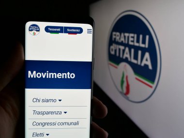 Stuttgart, Almanya - 07-11-2025: İtalyan partisi Fratelli d 'Italia' nın (FDL) internet sayfası olan cep telefonu logonun önünde ekranda. Telefon ekranının merkezine odaklan.