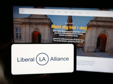 Stuttgart, Almanya - 07-11-2025: İnternet sitesi önünde ekranda Danimarkalı siyasi parti Liberal İttifakı 'nın (LA) logosunu taşıyan kişi görülüyor. Telefon ekranına odaklan.