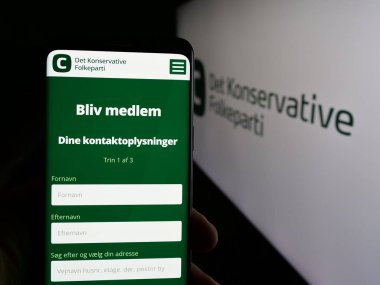 Stuttgart, Almanya - 07-11-2025: Danimarka partisi Detektif Konservatif Folkeparti 'nin (KF) internet sayfası logonun önünde duran kişi. Telefon ekranının merkezine odaklan.