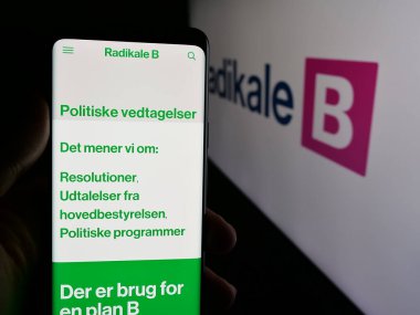 Stuttgart, Almanya - 07-11-2025: Danimarkalı siyasi parti Radikale Venstre 'nin (RV) web sayfası logonun önünde duran kişi. Telefon ekranının merkezine odaklan.