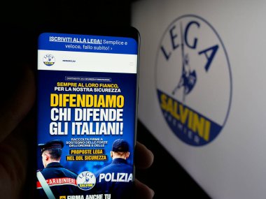 Stuttgart, Almanya - 07-17-2025: Logo önünde ekranda İtalyan partisi Lega per Salvini Premier (LSP) 'nin web sayfası bulunan kişi. Telefon ekranının merkezine odaklan.