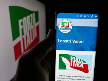 Stuttgart, Almanya - 07-17-2025: İtalyan siyasi partisi Forza Italia 'nın (FI) internet sayfası logo önünde bulunan kişi. Telefon ekranının merkezine odaklan.