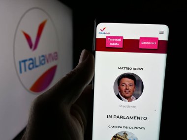 Stuttgart, Almanya - 07-17-2025: İtalyan siyasi partisi Italia Viva 'nın (IV) web sayfası logonun önünde duran kişi. Telefon ekranının merkezine odaklan.