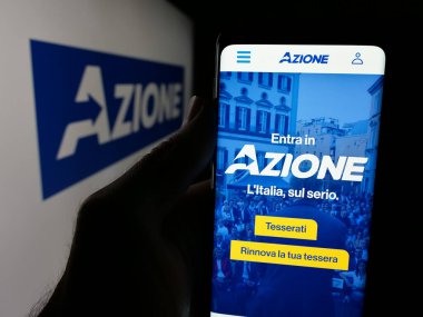 Stuttgart, Almanya - 07-17-2025: İtalyan siyasi partisi Azione 'nin web sayfası logonun önünde duran kişi. Telefon ekranının merkezine odaklan.