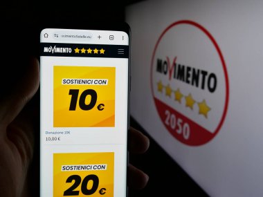 Stuttgart, Almanya - 07-17-2025: İtalyan partisi Movimento 5 Stelle 'nin (M5S) web sayfası logonun önünde duran kişi. Telefon ekranının merkezine odaklan.
