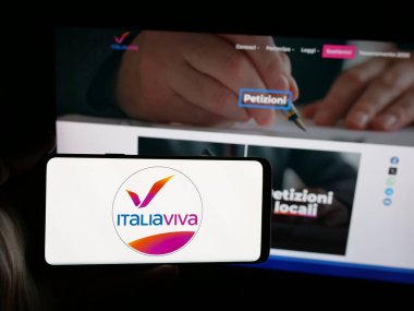 Stuttgart, Almanya - 07-17-2025: İtalyan siyasi partisi Italia Viva 'nın (IV) logosunu elinde tutan kişi web sitesinin önünde ekranda. Telefon ekranına odaklan.