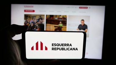 Stuttgart, Almanya - 07-18-2025: Web sayfası önünde üzerinde parti Esquerra Republicana de Catalunya (ERC) logosu bulunan kişi. Telefon ekranına odaklan.