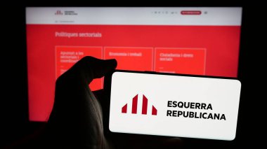 Stuttgart, Almanya - 07-18-2025: Web sayfası önünde üzerinde parti Esquerra Republicana de Catalunya (ERC) logosu bulunan cep telefonu sahibi kişi. Telefon ekranına odaklan.