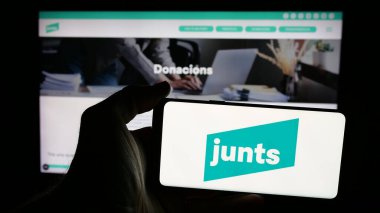 Stuttgart, Almanya - 07-18-2025: İspanyol siyasi parti Junts per Catalunya 'nın logosunun bulunduğu cep telefonu web sitesinin önünde. Telefon ekranına odaklan.