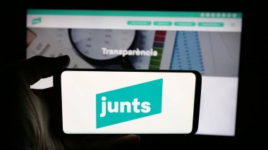 Stuttgart, Almanya - 07-18-2025: İspanyol siyasi partisi Junts per Catalunya 'nın logosunun bulunduğu cep telefonu web sitesinin önünde. Telefon ekranına odaklan.