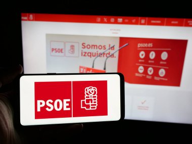 Stuttgart, Almanya - 07-18-2025: Web sitesinin önünde üzerinde Partido Socialista Obrero Espanol (PSOE) logosu bulunan kişi. Telefon ekranına odaklan.