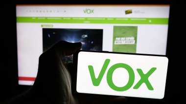 Stuttgart, Almanya - 07-18-2025: İspanyol siyasi partisi Vox 'un logosunun bulunduğu cep telefonu web sayfası önünde ekranda. Telefon ekranına odaklan.