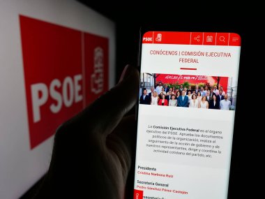 Stuttgart, Almanya - 07-18-2025: Partido Socialista Obrero Espanol 'un (PSOE) web sayfası logonun önünde duran kişi. Telefon ekranının merkezine odaklan.