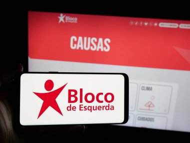 Stuttgart, Almanya - 07-18-2025: İnternet sitesi önünde üzerinde Portekiz partisi Bloco de Esquerda 'nın (BE) logosu bulunan kişi. Telefon ekranına odaklan.