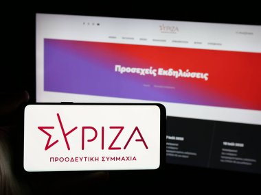 Stuttgart, Almanya - 07-18-2025: Sitenin önünde Syriza (Syriza) ekranında Synaspismos Rizospastikis Aristeras logosu bulunan kişi. Telefon ekranına odaklan.