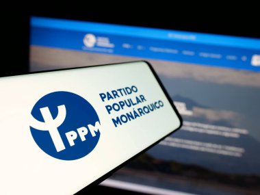 Stuttgart, Almanya - 07-18-2025: Partili Partili Popüler Monarquico (PPM) logosu olan akıllı telefon web sitesinin önünde ekranda. Telefon ekranının merkez soluna odaklan.