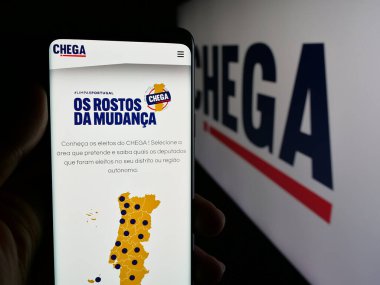 Stuttgart, Almanya - 07-18-2025: Portekiz siyasi partisi Chega 'nın (CH) web sayfası logonun önünde duran kişi. Telefon ekranının merkezine odaklan.