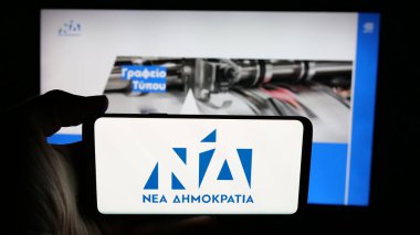 Stuttgart, Almanya - 07-18-2025: Yunan siyasi partisi Nea Dimokratia 'nın (ND) logosunun bulunduğu cep telefonu web sayfası önünde ekranda. Telefon ekranına odaklan.