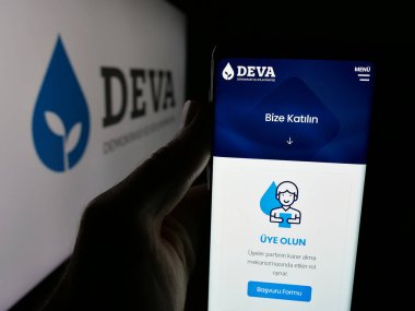 Stuttgart, Almanya - 07-23-2025: Demokrasi ve Atilim Partisi 'nin (DEVA) internet sayfası logonun önünde bulunan kişi. Telefon ekranının merkezine odaklan.