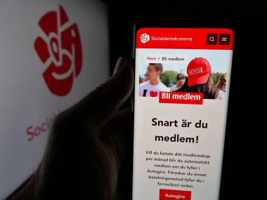 Stuttgart, Almanya - 07-23-2025: Logo önünde ekranda Sveriges Socialdemokratiska Arbetareparti SAP web sayfası bulunan kişi. Telefon ekranının merkezine odaklan.