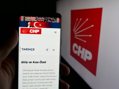 Stuttgart, Almanya - 07-23-2025: Türk Halk Partisi 'nin (CHP) internet sayfası logo önünde cep telefonu tutan kişi. Telefon ekranının merkezine odaklan.