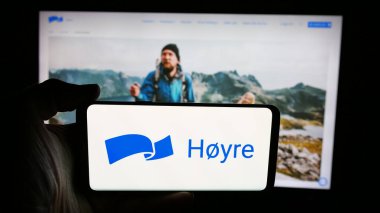 Stuttgart, Almanya - 07-24-2025: Norveç siyasi partisi Hoyre 'nin logosunu web sayfasının önünde tutan kişi. Telefon ekranına odaklan.