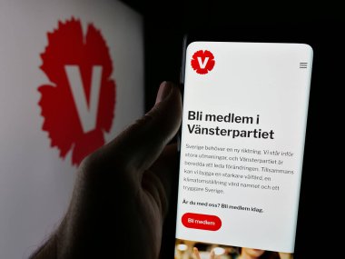 Stuttgart, Almanya - 07-24-2025: İsveçli siyasi parti Vansterpartiet 'in web sayfası logonun önünde duran kişi. Telefon ekranının merkezine odaklan.