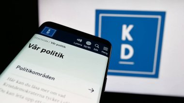 Stuttgart, Almanya - 07-24-2025: İsveç partisi Kristdemokraterna 'nın (KD) yer aldığı cep telefonu logosu önünde ekranda. Telefon ekranının sol üst kısmına odaklan.