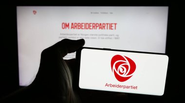Stuttgart, Almanya - 07-24-2025: Norveç siyasi partisi Arbeiderpartiet 'in logosunu web sayfasının önünde tutan kişi. Telefon ekranına odaklan.