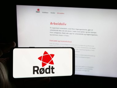 Stuttgart, Almanya - 07-24-2025: Web sitesinin önünde Norveçli siyasi parti Rodt 'un logosunu taşıyan kişi. Telefon ekranına odaklan.