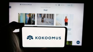 Stuttgart, Almanya - 07-24-2025: İnternet sayfasının önünde ekranda Fin siyasi partisi Kansallinen Kokoomus 'un logosuyla cep telefonu tutan kişi. Telefon ekranına odaklan.