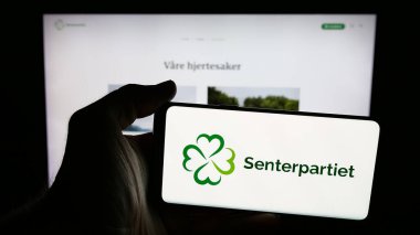 Stuttgart, Almanya - 07-24-2025: İnternet sayfası önünde Norveçli siyasi parti Senterpartiet 'in (Sp) logosunu elinde tutan kişi. Telefon ekranına odaklan.
