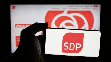 Stuttgart, Almanya - 07-25-2025: İnternet sayfasının önünde Suomen Sosialikraattinen Puolue (SDP) logosu olan cep telefonu sahibi kişi. Telefon ekranına odaklan.