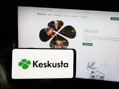 Stuttgart, Almanya - 07-25-2025: Fin siyasi partisi Suomen Keskusta 'nın logosunun bulunduğu akıllı telefonu web sitesinin önünde tutan kişi. Telefon ekranına odaklan.