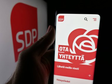 Stuttgart, Almanya - 07-25-2025: Logonun önünde Suomen Sosialidemokratinen Puolue 'nin (SDP) web sayfası bulunan kişi görülüyor. Telefon ekranının merkezine odaklan.