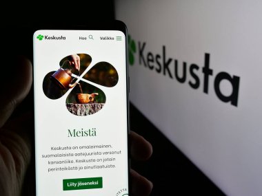 Stuttgart, Almanya - 07-25-2025: Fin siyasi partisi Suomen Keskusta 'nın internet sayfasını elinde tutan kişi logonun önünde ekranda. Telefon ekranının merkezine odaklan.