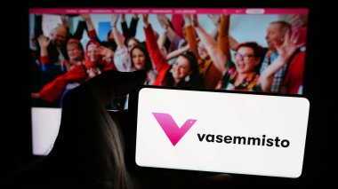 Stuttgart, Almanya - 07-25-2025: İnternet sayfasının önünde ekranda Fin siyasi partisi Vasemmistoliitto 'nun logosunun bulunduğu cep telefonu sahibi kişi. Telefon ekranına odaklan.