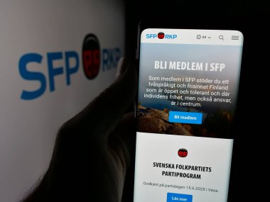 Stuttgart, Almanya - 07-25-2025: Fin partisi Svenska Folkpartiet 'in (SFP) web sayfası logonun önünde duran kişi. Telefon ekranının merkezine odaklan.