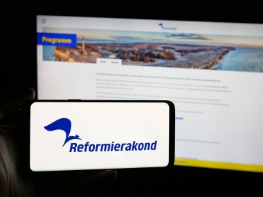Stuttgart, Almanya - 07-25-2025: Web sitesinin önünde Estonya siyasi partisi Eesti Reformierakond 'un logosunu taşıyan kişi. Telefon ekranına odaklan.