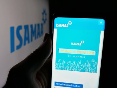 Stuttgart, Almanya - 07-28-2025: Estonya siyasi partisi Isamaa 'nın web sayfası logonun önünde duran kişi. Telefon ekranının merkezine odaklan.