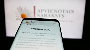 Stuttgart, Almanya - 07-28-2025: Letonya siyasi partisi Apvienotais Saraksts 'in web sitesi logo önünde ekranda. Telefon ekranının sol üst kısmına odaklan.