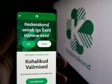 Stuttgart, Almanya - 07-28-2025: Estonya 'nın siyasi partisi Eesti Keskerakond' un web sayfası logonun önünde bulunan kişi. Telefon ekranının merkezine odaklan.