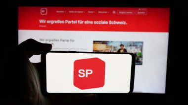 Stuttgart, Almanya - 07-28-2025: İnternet sayfası önünde Sozialdemokratische Partei der Schweiz (SP) logosunun bulunduğu cep telefonu sahibi kişi. Telefon ekranına odaklan.