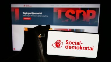 Stuttgart, Almanya - 07-28-2025: İnternet sayfasının önünde Lietuvos Socialdemokratu Partija (LSDP) partisinin logosunun bulunduğu cep telefonu sahibi kişi. Telefon ekranına odaklan.